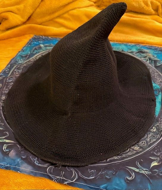 Black woven witch hat with a tall bent crown and wide brim