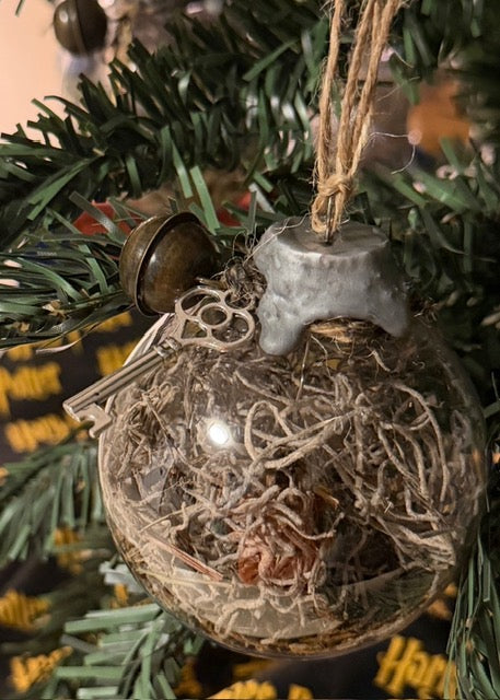 Close-up of handmade Protection Witch Ball with natural moss and antique charms