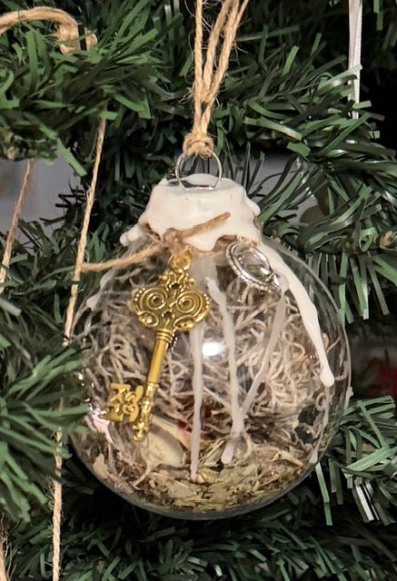 Close-up of handmade Cleansing Witch Ball with natural moss and charms