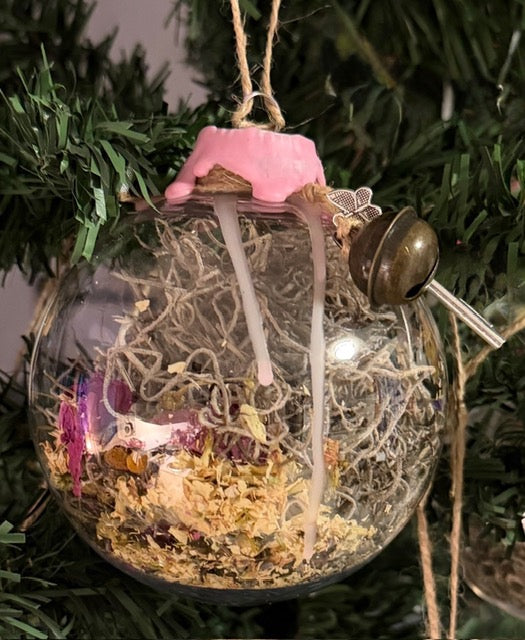 Close-up of handmade Self-Love & Harmony Witch Ball with pink wax, jute twine, botanicals, crystals, and charms